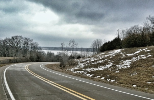 The Mississippi River can be seen in the distance as River Road makes a bend a few miles north of Keokuk, Iowa, on a gray March 2013 day.